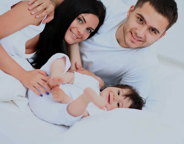 Rodina s malými dětmi do postele v ložnici — Stock fotografie