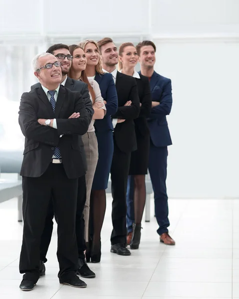 Team di professionisti con fiducia guardare avanti, in piedi nel mezzo dell'ufficio — Foto Stock