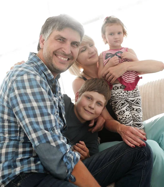 Famiglia con due bambini seduti insieme e guardando la fotocamera — Foto Stock