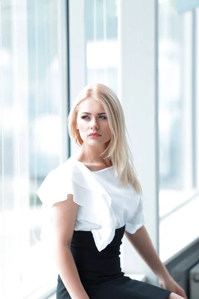 Moderne Geschäftsfrau sitzt am Fenster im Büro. — Stockfoto