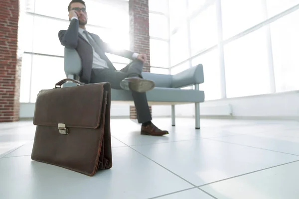 Biznesmen, trzymając jego teczki w biurze — Zdjęcie stockowe