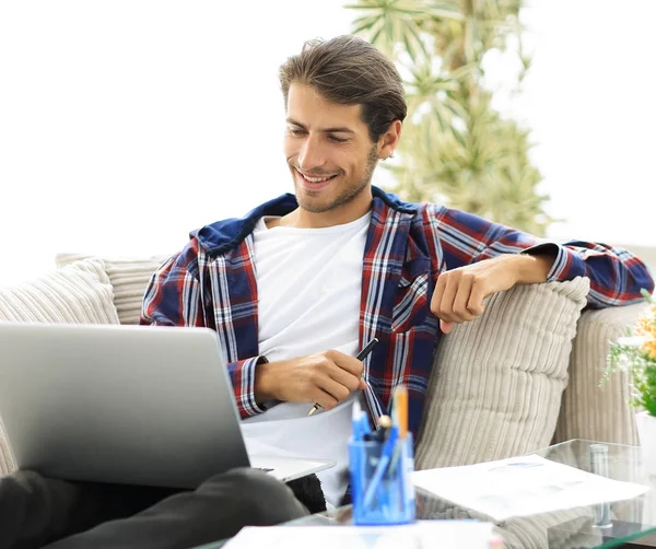 Ευτυχισμένος τύπος που εργάζονται με φορητό υπολογιστή από το σπίτι. έννοια του freelancing. — Φωτογραφία Αρχείου