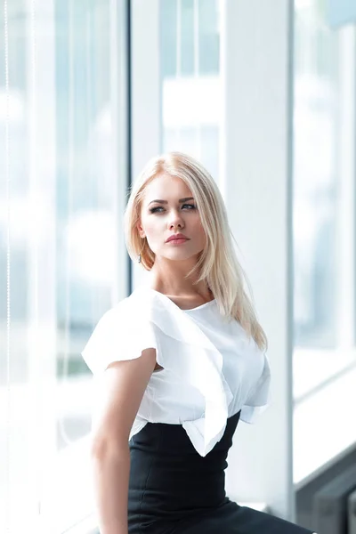 Mujer de negocios moderna sentada cerca de la ventana en la oficina . — Foto de Stock