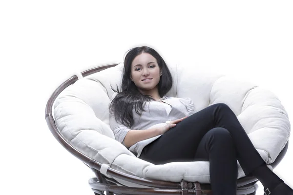 Nowoczesna młoda kobieta siedzi w okrągłym, przytulnym fotelu — Zdjęcie stockowe