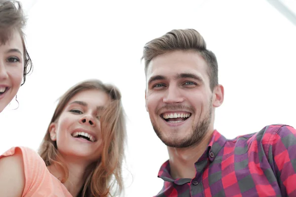Closeup of three young people smiling on white background Stock Image