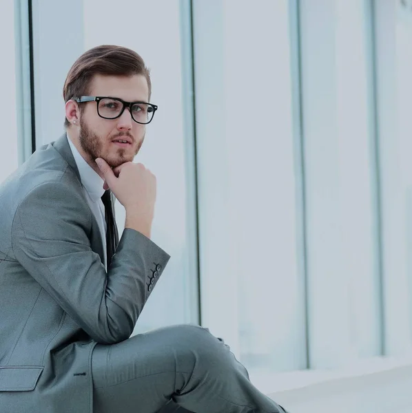 closeup of the Manager thoughtfully sitting beside the window