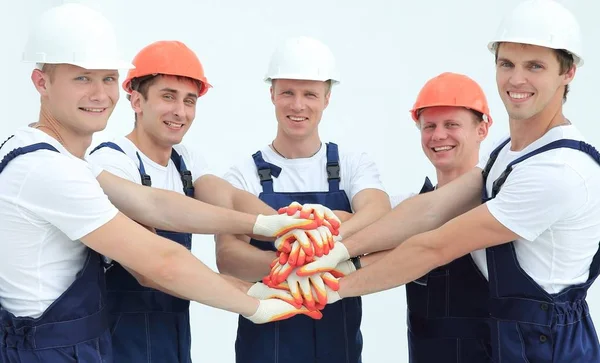 Equipe de construtores de pé com as mãos apertadas juntas — Fotografia de Stock