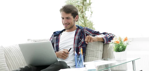 Счастливый молодой человек, работающий с ноутбуком из дома . — стоковое фото