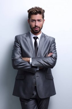 Çapraz kollarla poz veren genç iş adamı.