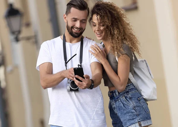 Пара счастливых улыбающихся туристов, гуляющих по городу — стоковое фото