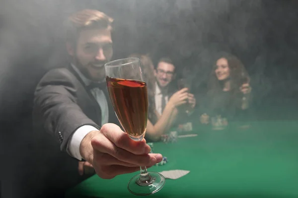 Pokerspieler hebt ein Glas Wein — Stockfoto