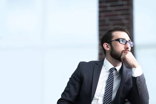 Bell'uomo d'affari pensa, seduto sul divano nel suo ufficio — Foto Stock