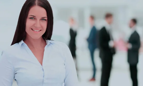 Успешная деловая женщина, стоящая со своим персоналом на заднем плане — стоковое фото