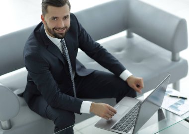 mali grafikler ile bir dizüstü bilgisayar üzerinde çalışan iş adamı