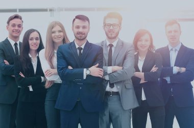 gülümseyen ve parlak bir pencerenin önünde emin iş takım ayakta