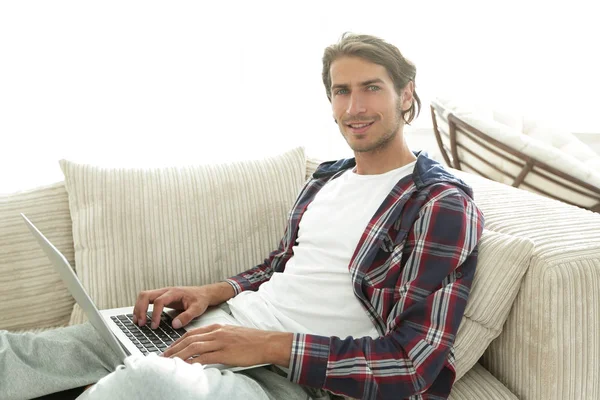 Ernsthafter junger Mann mit Laptop. — Stockfoto