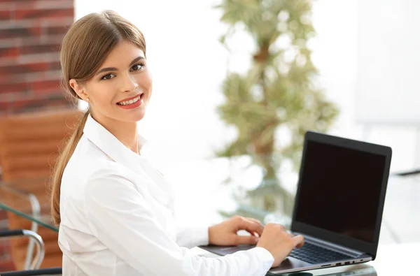 Ofisindeki masasında oturan genç bir iş kadını dizüstü bilgisayarla çalışıyor. — Stok fotoğraf