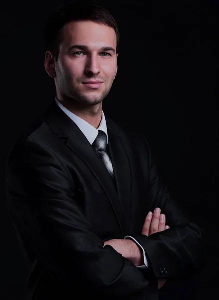 Happy business man klädd i svart kostym står och hopfällbara armar — Stockfoto