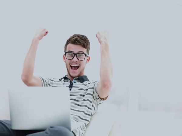 Happy young man using his laptop in bright living room. — Stock Photo, Image