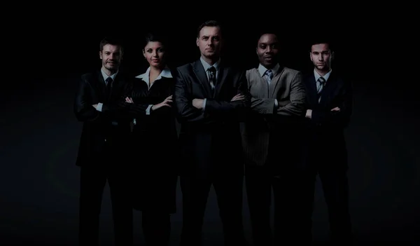Biznes drużyna stojący na ciemnym tle — Zdjęcie stockowe
