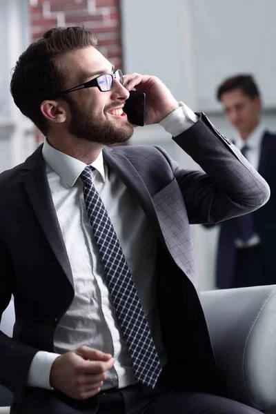Przystojny biznesmen mówiąc na telefon komórkowy w biurze — Zdjęcie stockowe