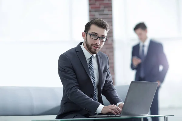 Hombre de negocios guapo está trabajando con el ordenador portátil en la oficina —  Fotos de Stock