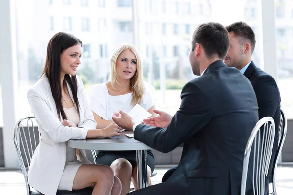 Business team discussing business issues, sitting at a table in a cafe. — Stock Photo, Image