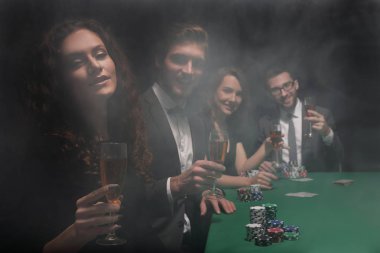 Casino oyun masasında oturan arkadaş grubu