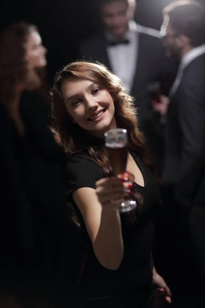 Красивая молодая женщина поднимает бокал в казино — стоковое фото