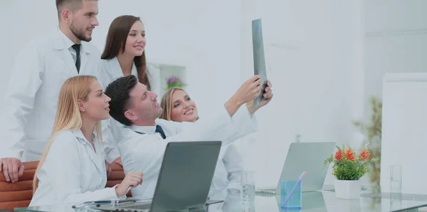 Smiling doctors working at office desk and analyzind the x-ray, — Stok Foto