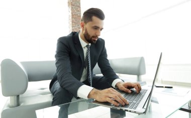 Modern ofis dizüstü bilgisayarda çalışan başarılı erkeğin