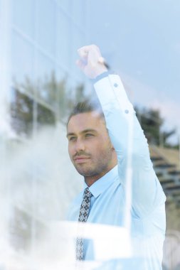 Camların arkasından manzara. Kendine güvenen iş adamı ofisinin penceresinden dışarı bakıyor.