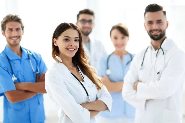 Médica atraente com estetoscópio médico na frente do grupo médico — Fotografia de Stock