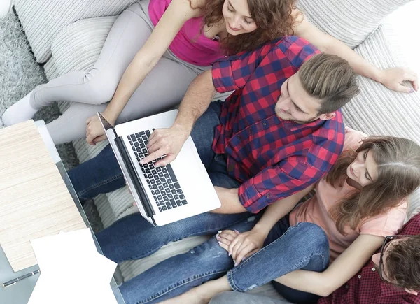 Grupo de amigos com um laptop, discutindo o vídeo — Fotografia de Stock
