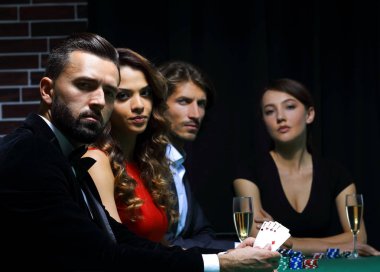 Kumarhanede poker oynayan bir grup insanın yan görünüşü