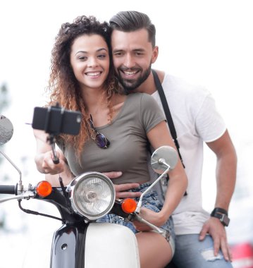 Erkek ve dişi bir kasabada motorlu scooter.