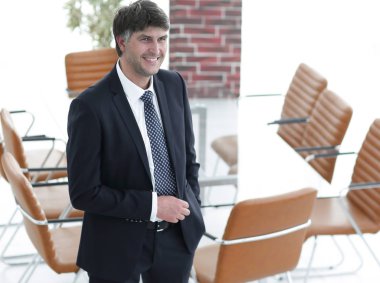 Bir boş toplantı odasında duran iş adamı