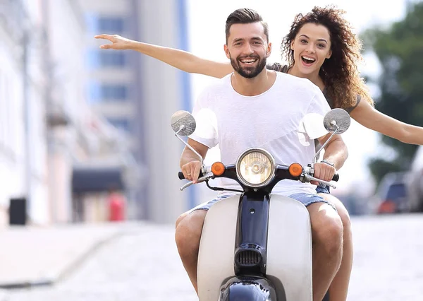 Feliz joven pareja montando un scooter en la ciudad en un día soleado —  Fotos de Stock