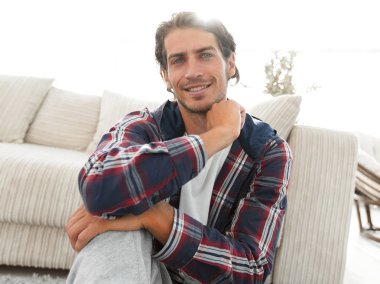 mutlu adam yeni bir daire içinde halı üzerinde oturan.