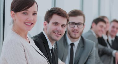 Ofiste toplantı sırasında kameraya bakarak zarif ortak çalışanlar