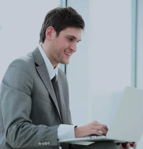 Smiling student blogger with an open laptop sitting near the win — Stock Photo, Image