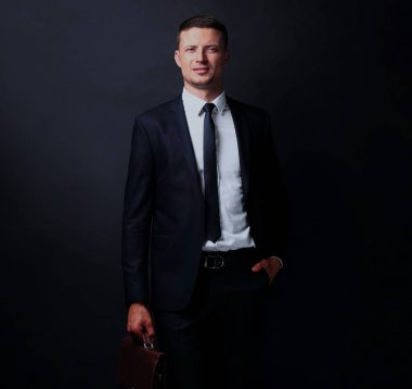 koyu arka plan üzerinde yakışıklı kendine güvenen işadamı