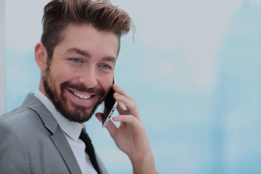 Yakışıklı iş adamı smartphone kullanarak bir ofiste