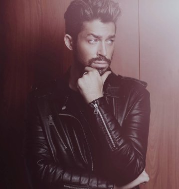 Ahşap duvara yaslanmış yakışıklı bir adamın portresi..