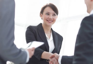 İş kadını toplantı sırasında bir işadamıyla tokalaşıyor.