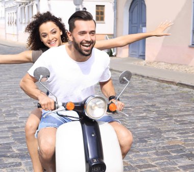 mutlu genç bir çift bir scooter üzerinde eğleniyor
