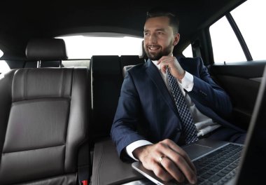 Arabanın içinde otururken kendine güvenen iş adamı