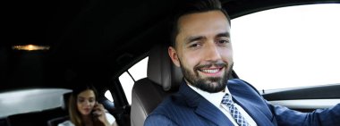 Çekici, zarif, ciddi adam iyi araba kullanıyor.