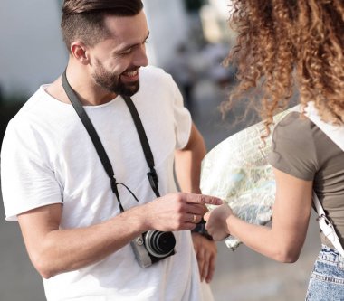 Genç çift mutlu görünürken bir rehbere bakıyor.