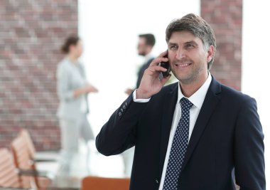 Kendine güvenen iş adamı telefonda konuşuyor..